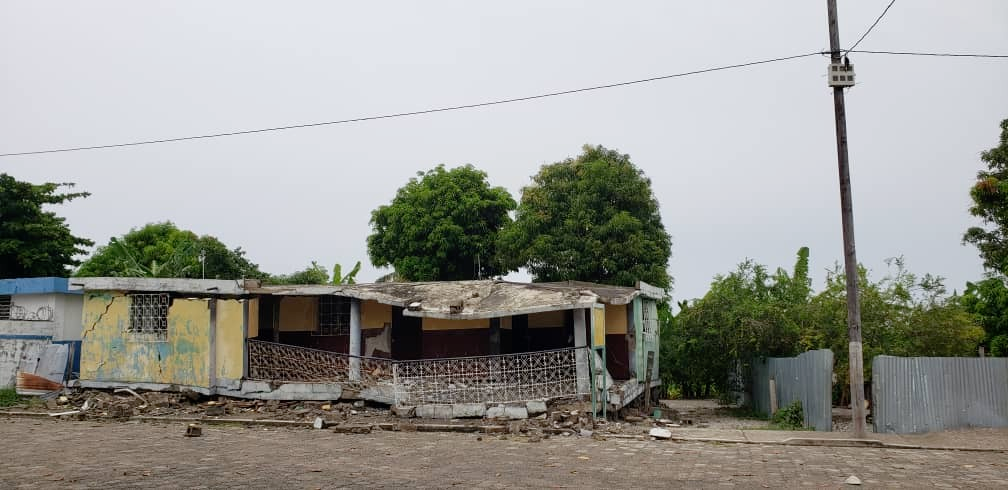 Earthquake destroyed house, but microgrid poles unharmed. Courtesy EarthSpark International
