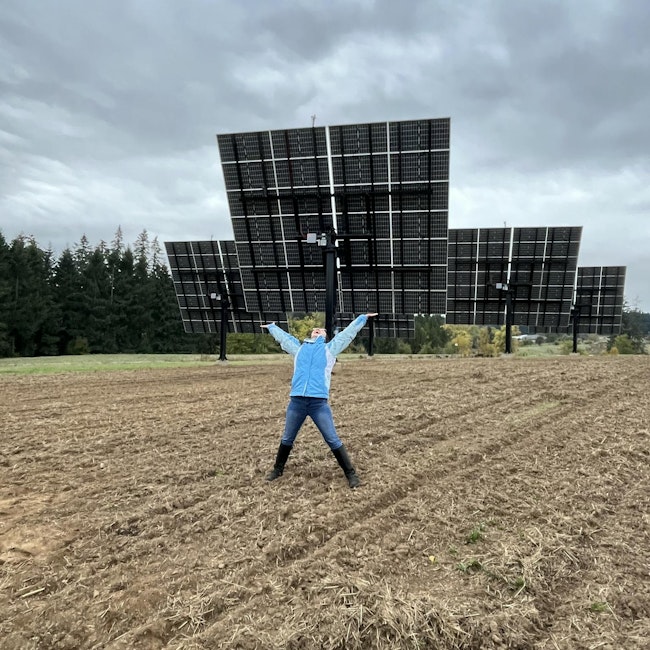 Deborah Westlight, operations manager with the Oregon Clean Power Cooperative, raises her arms in celebration of the solar panel portion of the project.