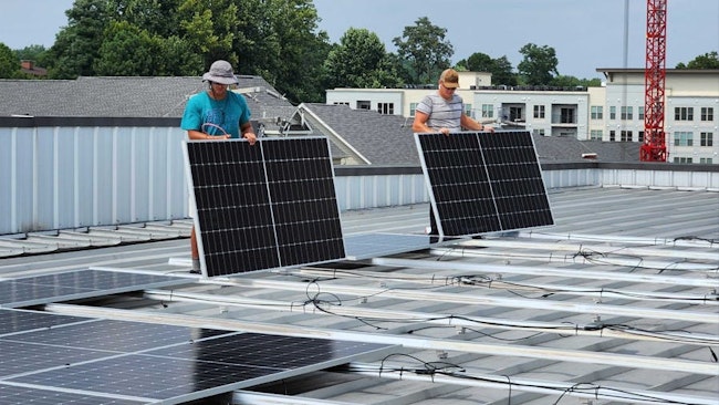 Solar installers wire-managing commercial panels on a self-storage facility in Virginia. Image credit Virtue Solar