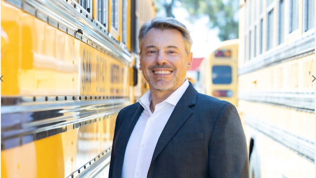 Gregory Poilasne, CEO and founder of Nuvve Holding, stands in the midst of an EV bus fleet. Image credit Nuvve