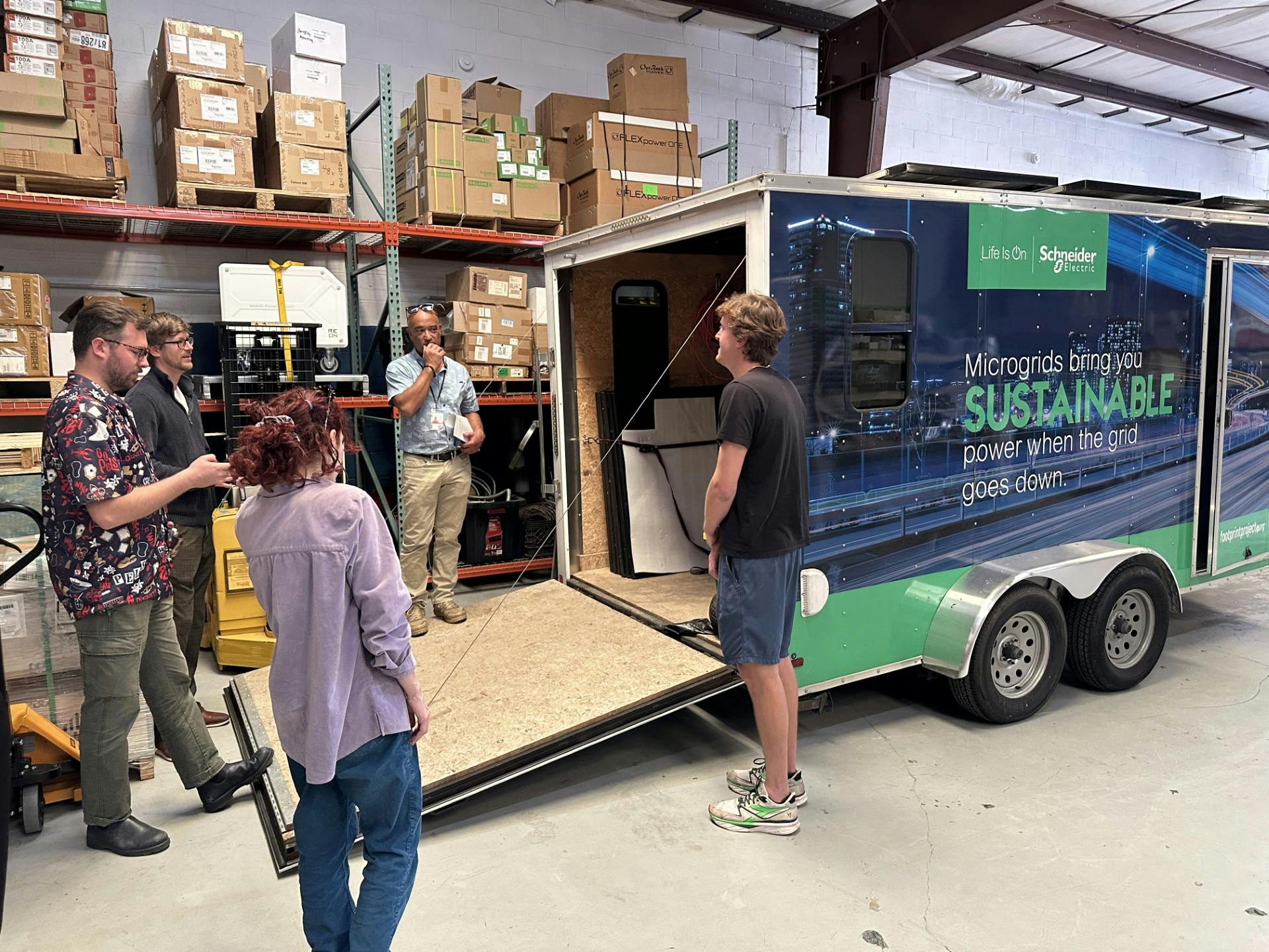 Some of the Footprint Project team gathers around in preparing to roll out a mobile microgrid.