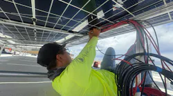Worker connecting solar portion of the Chiricahua Community Health Center microgrid in Arizona. Image credit Collective Energy